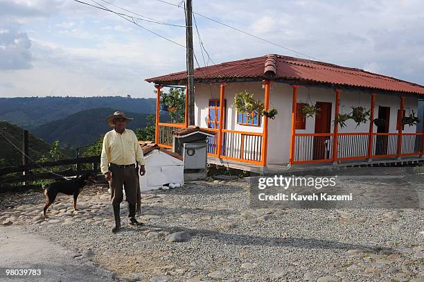 Typical Paisa man stands outside his coloorful house on the outskirts of Salento. Salento is a small town in the hills near the city of Pereira. It...