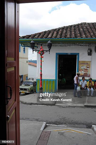 Men sit outside a bar in the main square, Salento. Salento is a small town in the hills near the city of Pereira. It is known for its trout fishing...