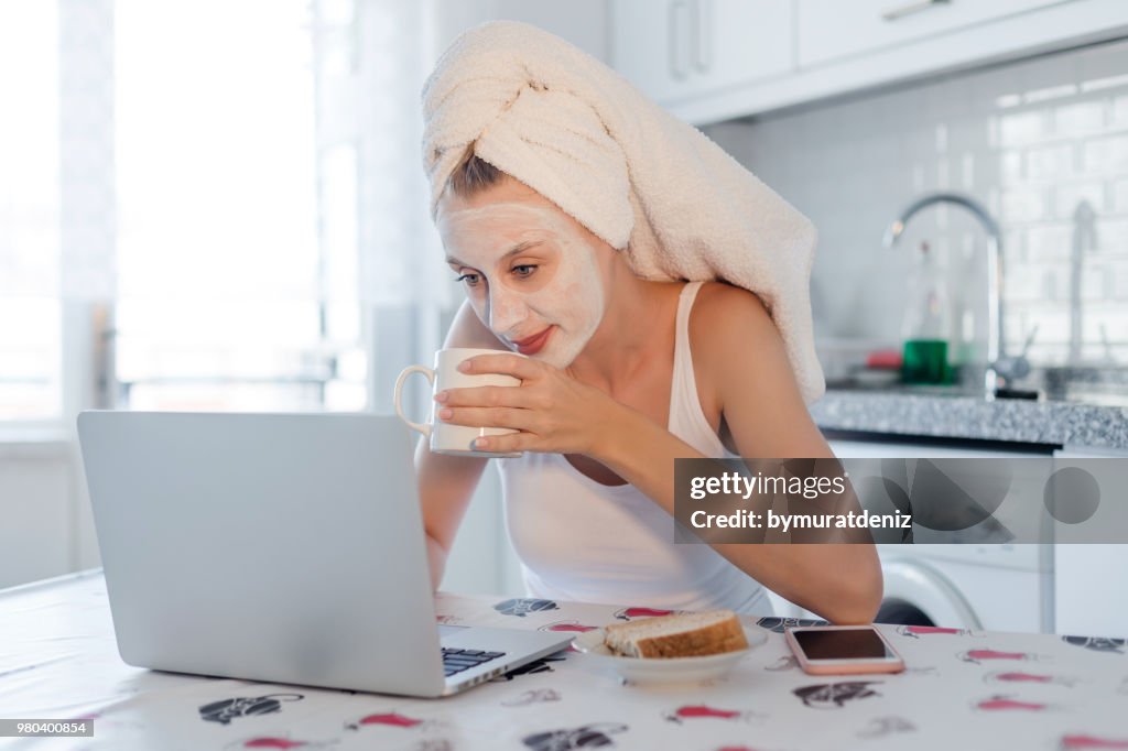 Femme avec un masque à l’aide d’ordinateur portable