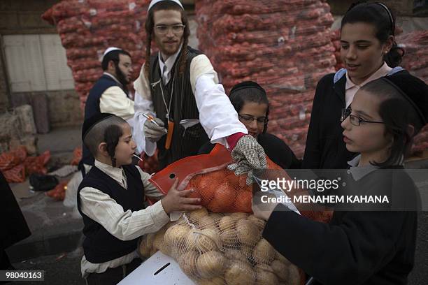 Ultra-Orthodox Jews carry donated food for the poor before Pesach holiday from a distribution center at their conservative neighbourhood in Jerusalem...