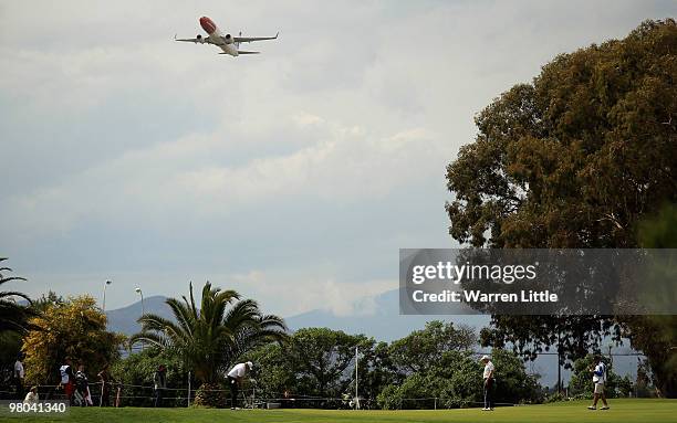 Michael Jonzon of Sweden putts out on the 12th green as a plane takes-off during the first round of the Open de Andalucia 2010 at Parador de Malaga...