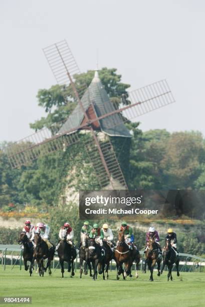 Pack of jockeys and their mounts passing a windmill as they race on 2 October 1994 during the Prix de L'Arc de Triomphe in Longchamps near Paris,...