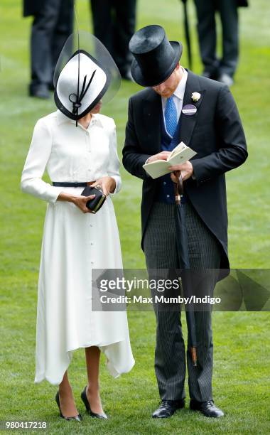 Meghan, Duchess of Sussex and Prince Harry, Duke of Sussex study a race card as they attend day 1 of Royal Ascot at Ascot Racecourse on June 19, 2018...