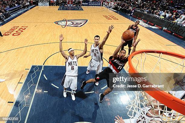 Andre Miller of the Portland Trail Blazers shoots against Courtney Lee and Yi Jianlian of the New Jersey Nets during the game on February 23, 2010 at...