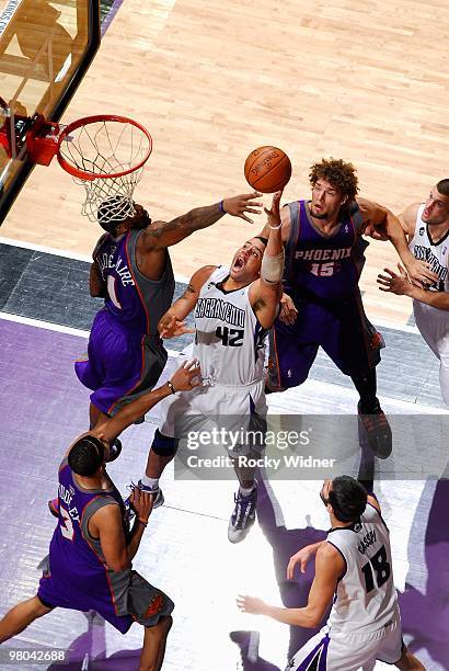 Sean May of the Sacramento Kings puts a shot up over Amar'e Stoudemire and Robin Lopez of the Phoenix Suns during the game on February 5, 2010 at...