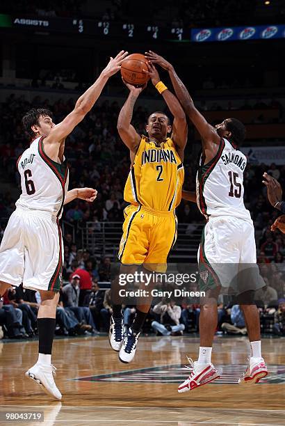 Earl Watson of the Indiana Pacers goes up for a shot against Andrew Bogut and John Salmons of the Milwaukee Bucks during the game at the Bradley...