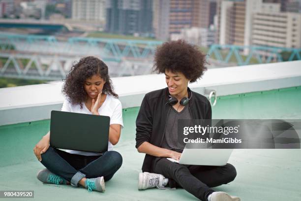 young couple are working on a computer on the roof - mamigibbs stock pictures, royalty-free photos & images