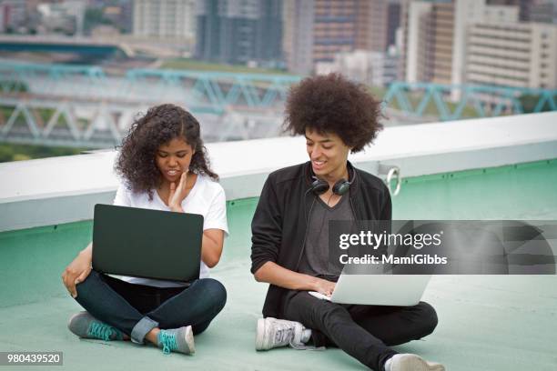 young couple are working on a computer on the roof - mamigibbs imagens e fotografias de stock