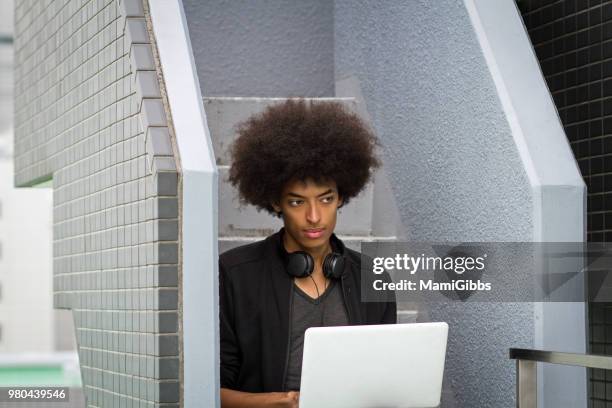 young man is working on a computer on the rooftop - mamigibbs stock pictures, royalty-free photos & images