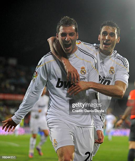 Gonzalo Higuain of Real Madrid celebrates with Alvaro Arbeloa after scoring his first goal during La Liga match between Getafe and Real Madrid at the...