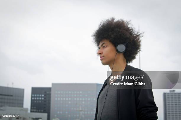 young man is relaxing on the rooftop - mamigibbs imagens e fotografias de stock