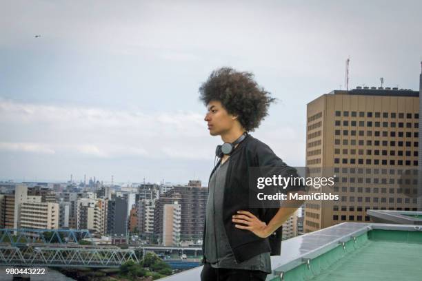 young man is relaxing on the rooftop - mamigibbs stockfoto's en -beelden