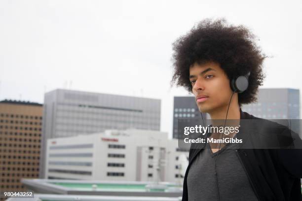 young man is relaxing on the rooftop - mamigibbs stock pictures, royalty-free photos & images