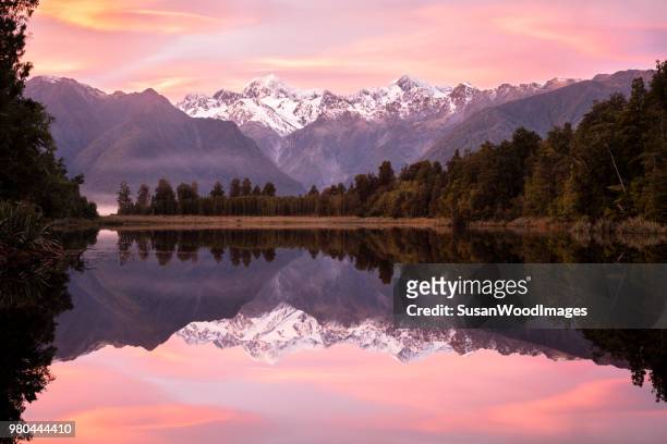 rosa sonnenaufgang lake matheson, neuseeland - south westland stock-fotos und bilder
