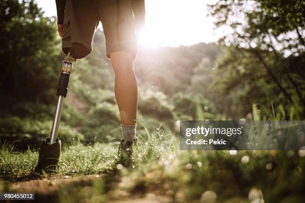 jonge geamputeerde man doorbrengen vrijetijdsbesteding in de natuur - amputatie stockfoto's en -beelden