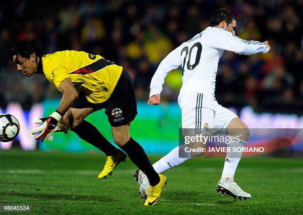 Getafe's Argentinian goalkeeper Oscar Ustari vies for the ball with Real Madrid's Argentinian forward Gonzalo Higuain during a Spanish league...