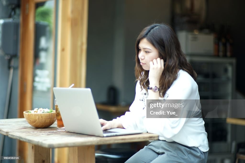 Woman working with a laptop at a bar