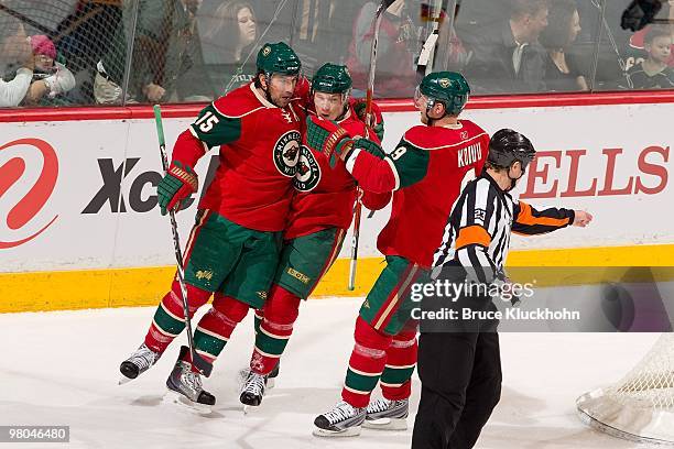 Andrew Brunette celebrates with his teammates Antti Miettinen and Mikko Koivu of the Minnesota Wild against the Calgary Flames during the game at the...