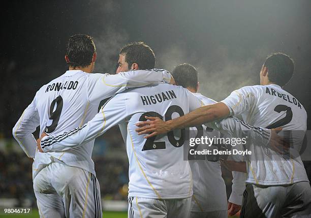 Gonzalo Higuain of Real Madrid celebrates with Cristiano Ronaldo and Alvaro Arbeloa after scoring his 2nd goal during La Liga match between Getafe...