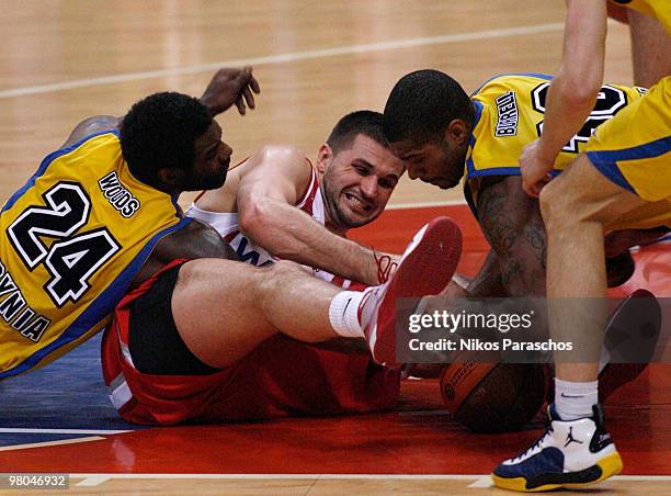 Qyntel Woods, #24 of Asseco Prokom Gdynia competes with Linas Kleiza, #11 of Olympiacos Piraeus and Ronnie Burrell, #30 of Asseco Prokom Gdynia...