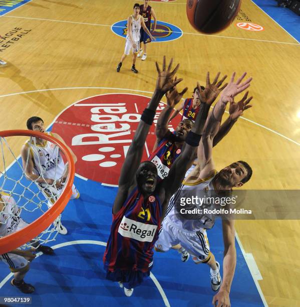 Boniface Ndong, #21 of Regal FC Barcelona and Pete Mickeal, #33 competes with Marko Jaric, #8 of Real Madrid during the Euroleague Basketball...