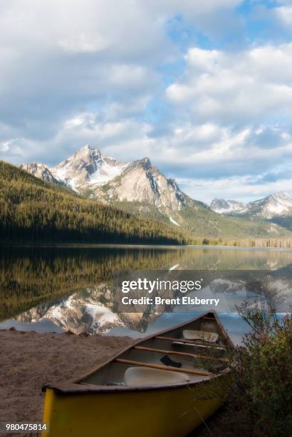 mountains of sawtooth range reflecting in stanley lake with canoe on shore, custer county, idaho, usa - sawtooth national recreation area stock pictures, royalty-free photos & images