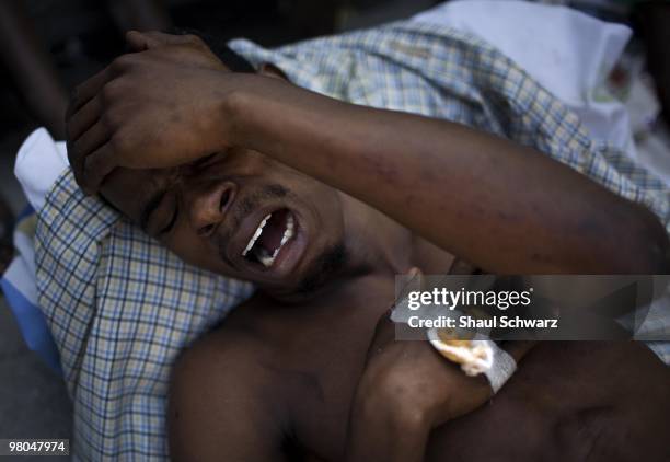 Man cries outside a make shift hospital near the Cathedral in Port Au Prince on January 15, 2010 in Port au Prince, Haiti. As the world rallies to...