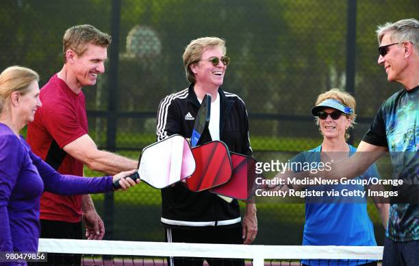 Pickleball instructor Mike Fischer, center, congratulates his students after practice on the pickleball courts at Bonita Canyon Sports Park in...