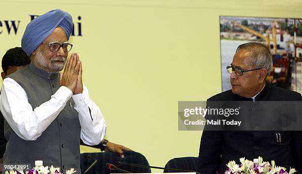 Prime Minister Manmohan Singh greets as Finance Minister Pranab Mukherjee looks on at a conference entitled 'Building Infrastructure Challenges and...