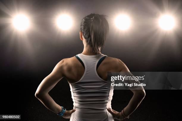 rear view of female athlete wearing sports bra standing with hands - atleta de campo e pista - fotografias e filmes do acervo