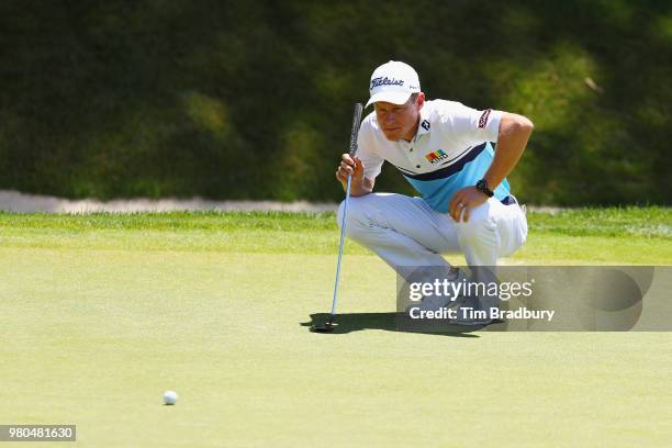 Peter Malnati of the United States lines up a putt on the 18th green during the first round of the Travelers Championship at TPC River Highlands on...