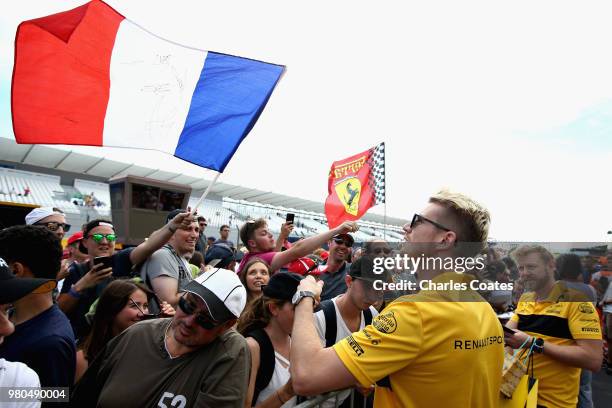 Nico Hulkenberg of Germany and Renault Sport F1 signs autographs for fans during previews ahead of the Formula One Grand Prix of France at Circuit...