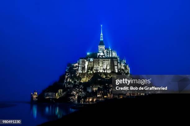 mont saint-michel fortified monastery on island at night, normandy, france - bob michel stock pictures, royalty-free photos & images