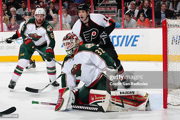 Greg Zanon and Niklas Backstrom of the Minnesota Wild set up to defend against the attack of Ian Laperriere of the Philadelphia Flyers on March 25,...