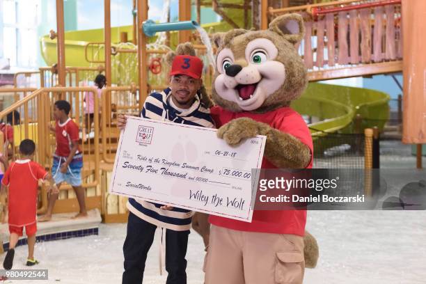 Chance the Rapper poses with a check presented to SocialWorks Kids of the Kingdom during the grand opening of Great Wolf Lodge Illinois on June 21,...