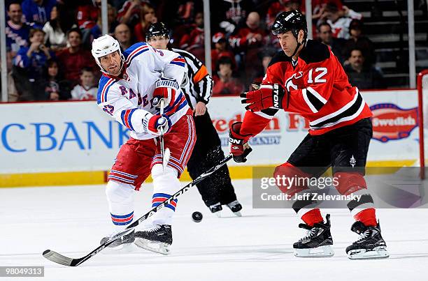 Michal Rozsival of the New York Rangers clears the puck in front of Brian Rolston of the New Jersey Devils at the Prudential Center on March 25, 2010...