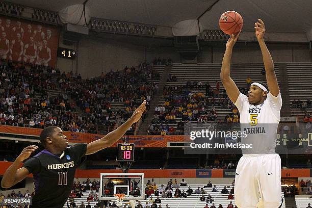 Kevin Jones of the West Virginia Mountaineers attempts a shot against Matthew Bryan-Amaning of the Washington Huskies during the east regional...