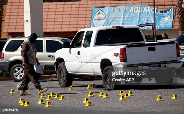 Member of the Mexican police walks next to a pick up truck in Ciudad Juarez, on March 25 where two corpses were found. Ciudad Juarez, with 1.3...