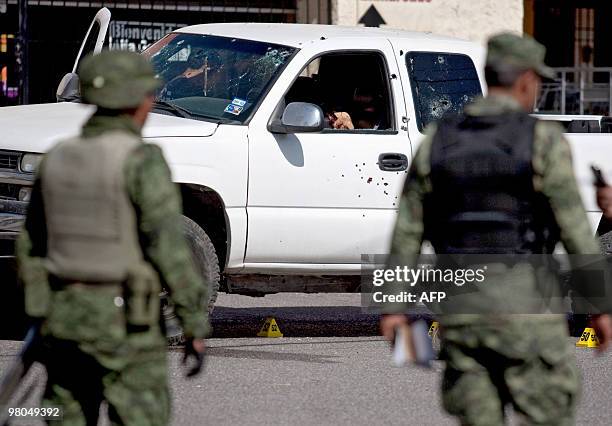 Two members of the Mexican army stand near a pick up truck in Ciudad Juarez, on March 25 where two corpses were found. Ciudad Juarez, with 1.3...