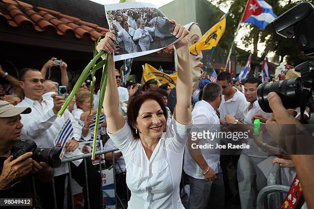Singer Gloria Estefan holds aloft a photograph of Cuba's Las Damas de Blanco as she marches in support of them on March 25, 2010 in Miami, Florida....