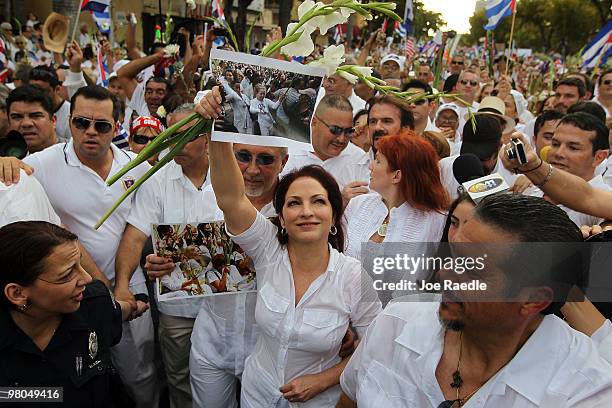 Singer Gloria Estefan holds aloft a photograph of Cuba's Las Damas de Blanco as she along with her husband, Emilio Estefan , and others march in...