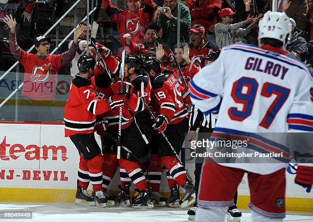 Ilya Kovalchuk of the New Jersey Devils is congratulated by his teammates after scoring a first-period goal as Matt Gilroy skates away dejected...