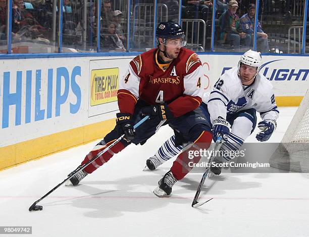 Zach Bogosian of the Atlanta Thrashers carries the puck against Francois Beauchemin of the Toronto Maple Leafs at Philips Arena on March 25, 2010 in...