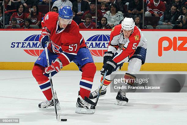 Benoit Pouliot of the Montreal Canadiens skates with the puck in front of Bryan Allen of the Florida Panthers during the NHL game on March 25, 2010...
