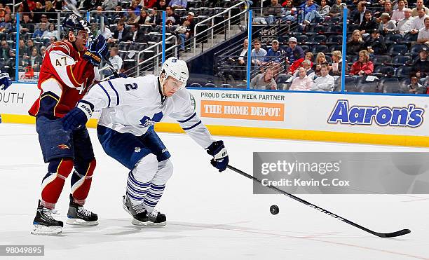 Luke Schenn of the Toronto Maple Leafs controls the puck against Rich Peverley of the Atlanta Thrashers at Philips Arena on March 25, 2010 in...
