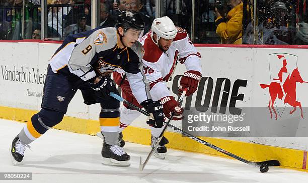 Marcel Goc of the Nashville Predators battles for the puck against Adrian Aucoin of the Phoenix Coyotes on March 25, 2010 at the Bridgestone Arena in...