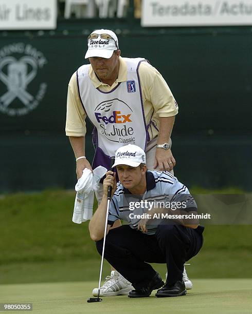 David Toms and his caddy check a putt in final-round play at the FedEx St. Jude Classic May 30, 2004 at the Tournament Players Club Southwind,...