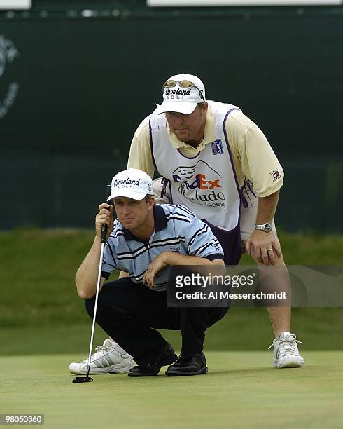 David Toms and his caddy check a putt in final-round play at the FedEx St. Jude Classic May 30, 2004 at the Tournament Players Club Southwind,...