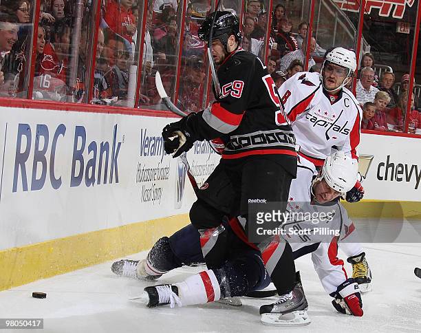 Chad LaRose of the Carolina Hurricanes gets tangled up along the boards with Mike Knuble of the Washington Capitals during their NHL game on March...