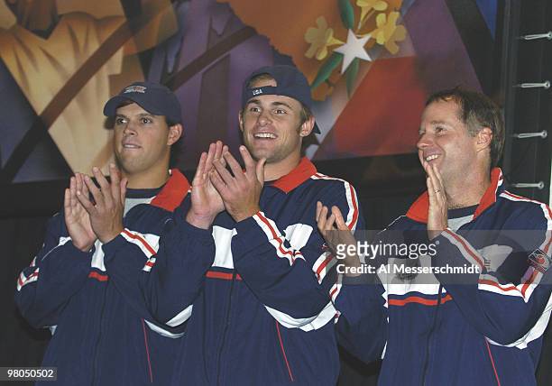 Bob Bryan, Andy Roddick and captain Patrick McEnroe applaud during the 2004 David Cup semifinal draw ceremony September 23, 2004 aboard the USS...